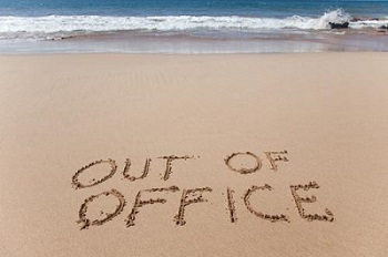 out of office written on a beach